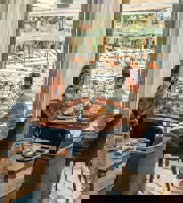 Couple Enjoying Lunch at Camiral Bistro with Terrace and Pool Views