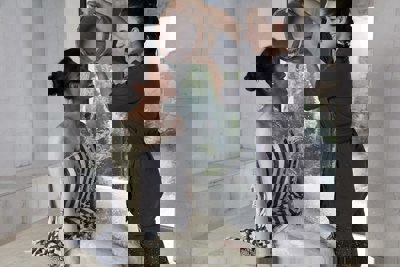 Woman receives hammam spa treatment in blue striped towel in luxury white tiled hammam