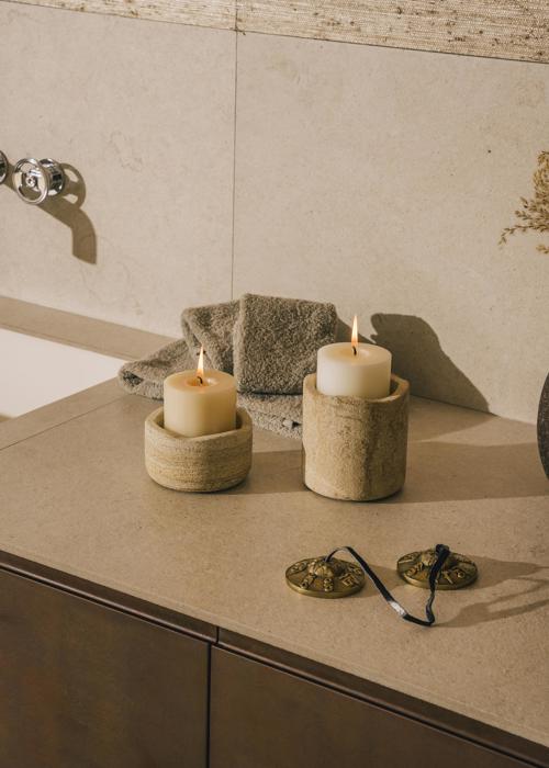 Two lit candles in elegant stone candleholders at luxury spa at 5* Resort