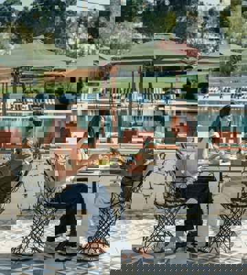 Couple Dining at Poolside Terrace Restaurant at Camiral Bistro With Garden and Pool Views