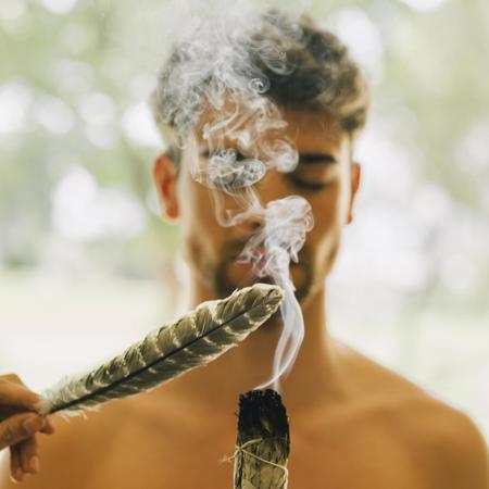 Feather hovering over incense in front of man experiencing revive ritual at Cairal wellness spa