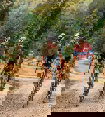 Two Cyclists Riding Gravel Bikes Through Forest Trails at PGA Catalunya Resort in Girona