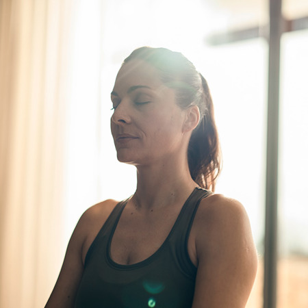 Woman meditate with eyes close and black top at wellness spa at 5* luxury resort