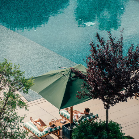 Couples Relaxing at Hotel Camiral Pool - Best Resort Offers in Girona