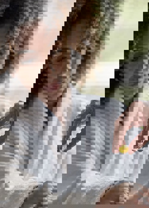 Woman in robe received massage oil on wrist for hand massage and manicure at luxury resort