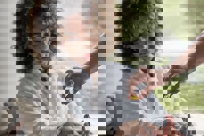 Woman in robe received massage oil on wrist for hand massage and manicure at luxury resort