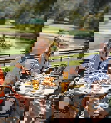 Friends Enjoying Lunch and Drinks on Golf Course View Terrace at Camiral Resort