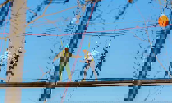 Zipline with 2 men completing team building activity