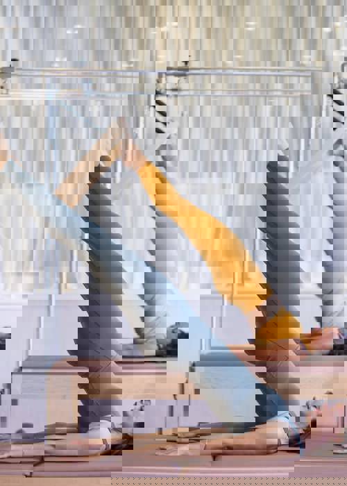 2 women perform pilates positions in active wear in luxury pilates room at Camiral Resort