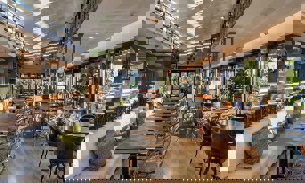 Elegant The Club Cafe Interior with Bar Seating and Natural Light Dining Area