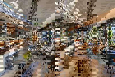 Elegant The Club Cafe Interior with Bar Seating and Natural Light Dining Area