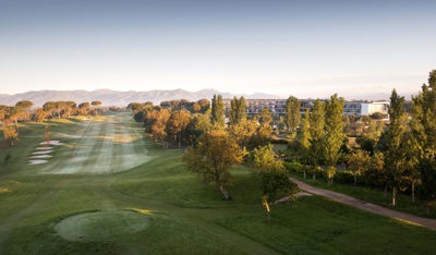 Panoramic view of the Camiral golf course fairway and hotel at sunset.