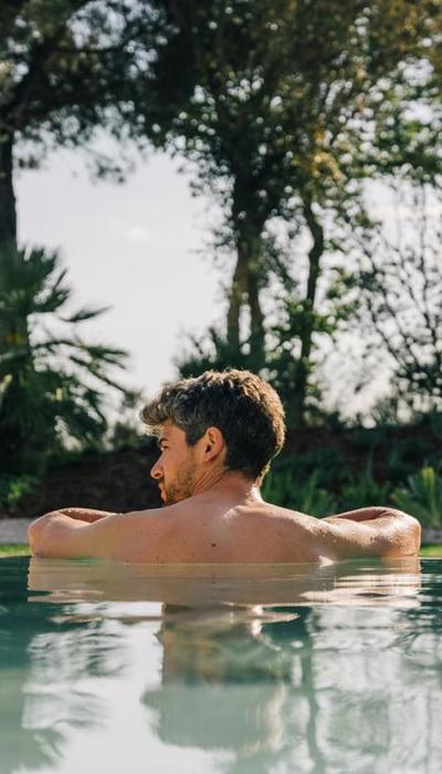 Man enjoys relaxig swim at 5* luxury wellness spa in Costa Brava