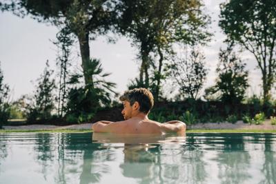Man enjoys relaxig swim at 5* luxury wellness spa in Costa Brava