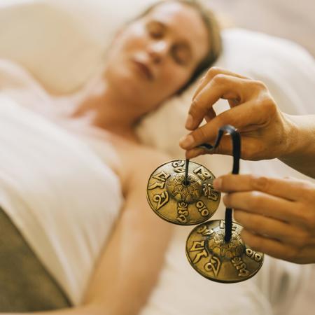 Woman with eyes closed experiences mindfullness treatment at luxury wellness spa