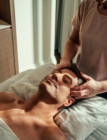 Man recieves head massage at Camiral luxury 5* PGA golf resort in Catalunya